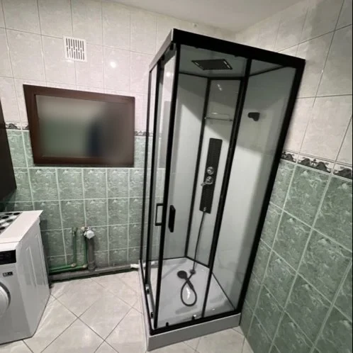 Łazienka z czarną kabiną prysznicową i pralką — DobryHydraulik Gdańsk