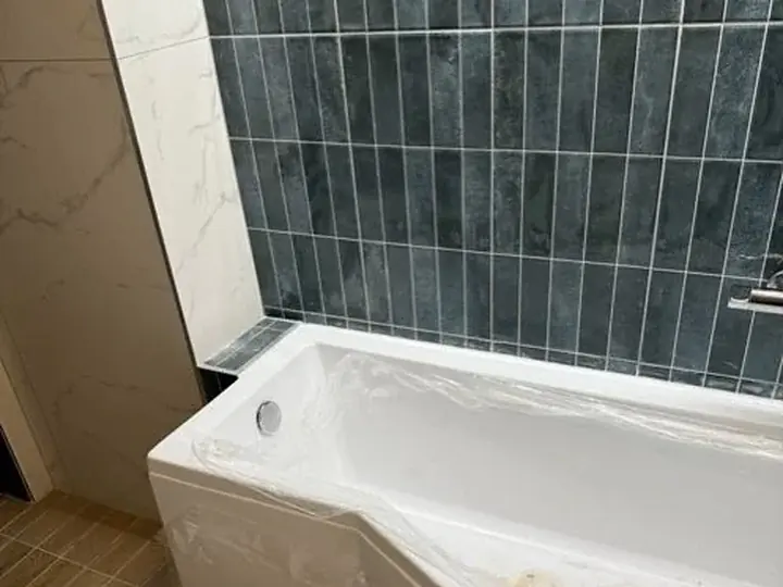 Nowa wanna przy granatowych płytkach — DobryHydraulik Gdańsk