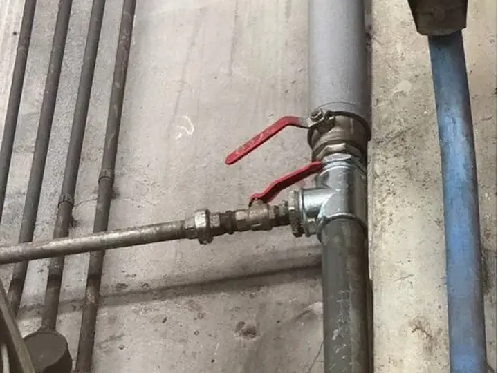Główny zawór z czerwoną rączką na rurach — DobryHydraulik Gdańsk